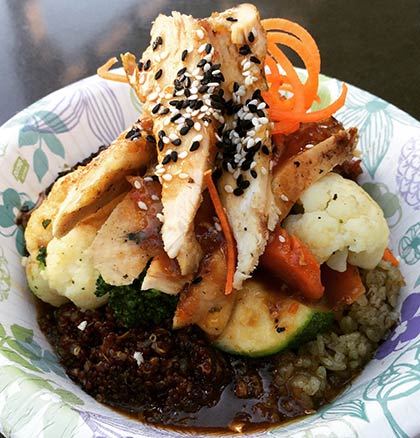 Asian Grain Bowls on Maui with ancient grains, fresh vegetables and chicken topped with sesame seeds and sauce.