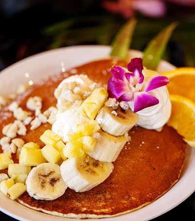 Kaanapali breakfast options include mac nut pancakes with banana and whipped cream.