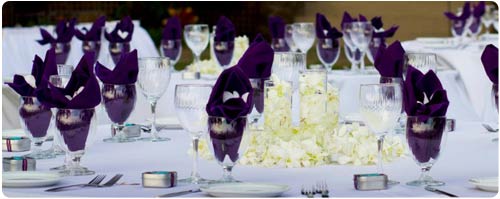 A wedding table setting complete with linens, silverware, china and more at a catered Maui wedding in West Maui.