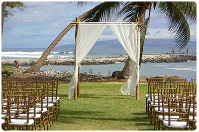 Hawaiian Wedding Traditions are complimented by a bamboo chuppa wedding arch. Here at Olowalu plantation Maui.
