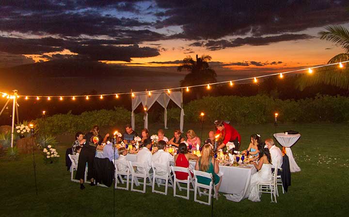 A private chef dinner on Maui with the sun setting in the background.